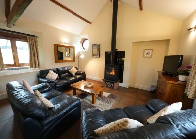 The Leat House comfy seating with the log burner lit