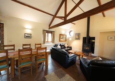 The comfy seating with the log burner lit and dining table